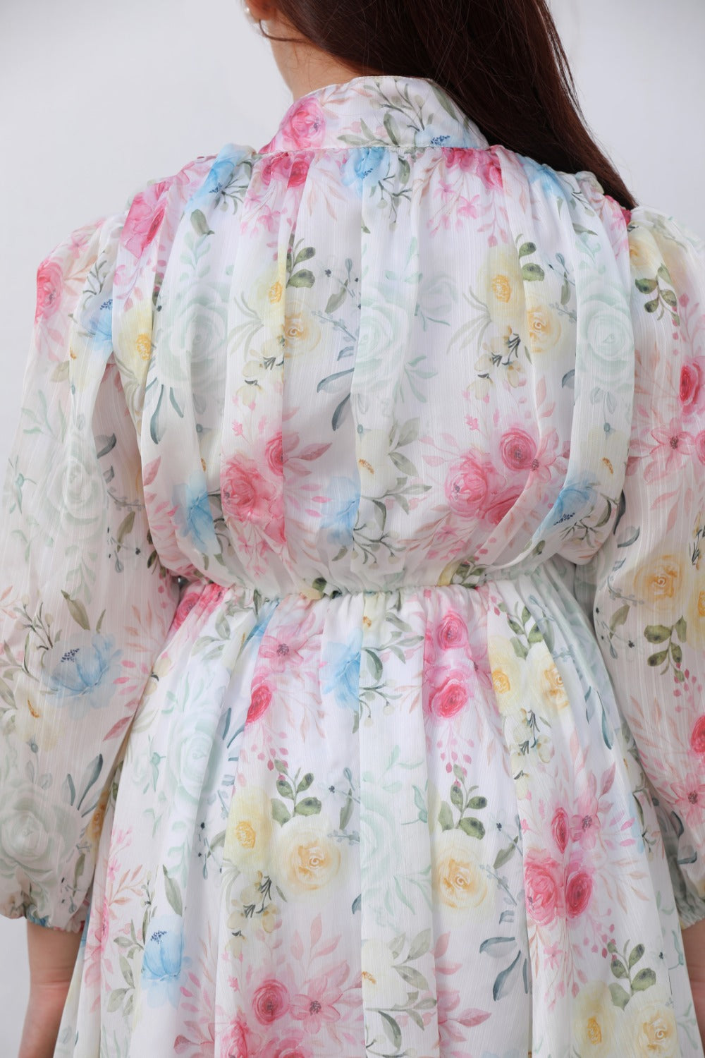 Close-up of belted waist detail on white floral long-sleeve dress