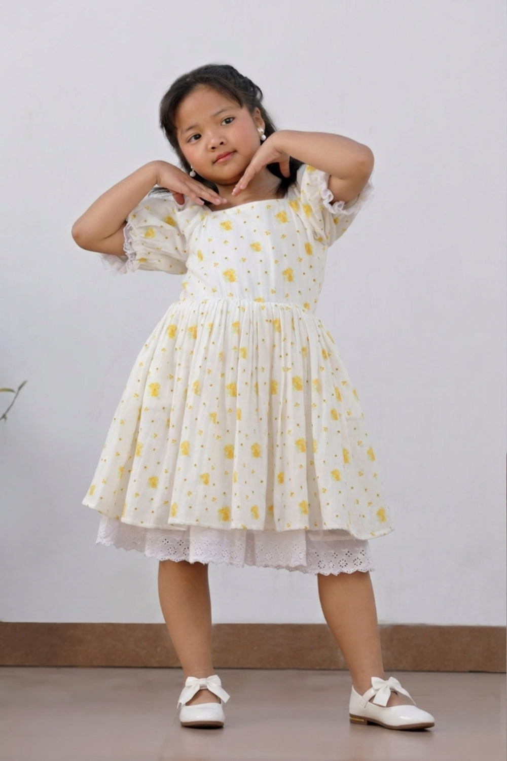 Full-length front view of girl in yellow floral dress with lace underskirt, alternate angle