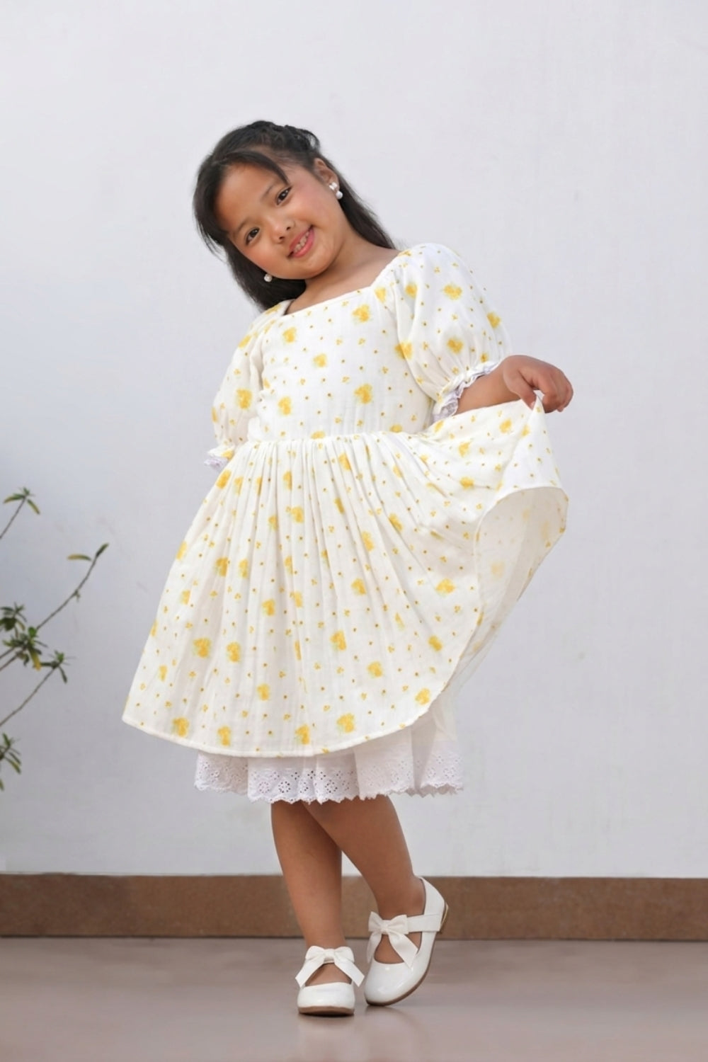 Girl in cream floral dress twirling, showing lace underskirt and full silhouette