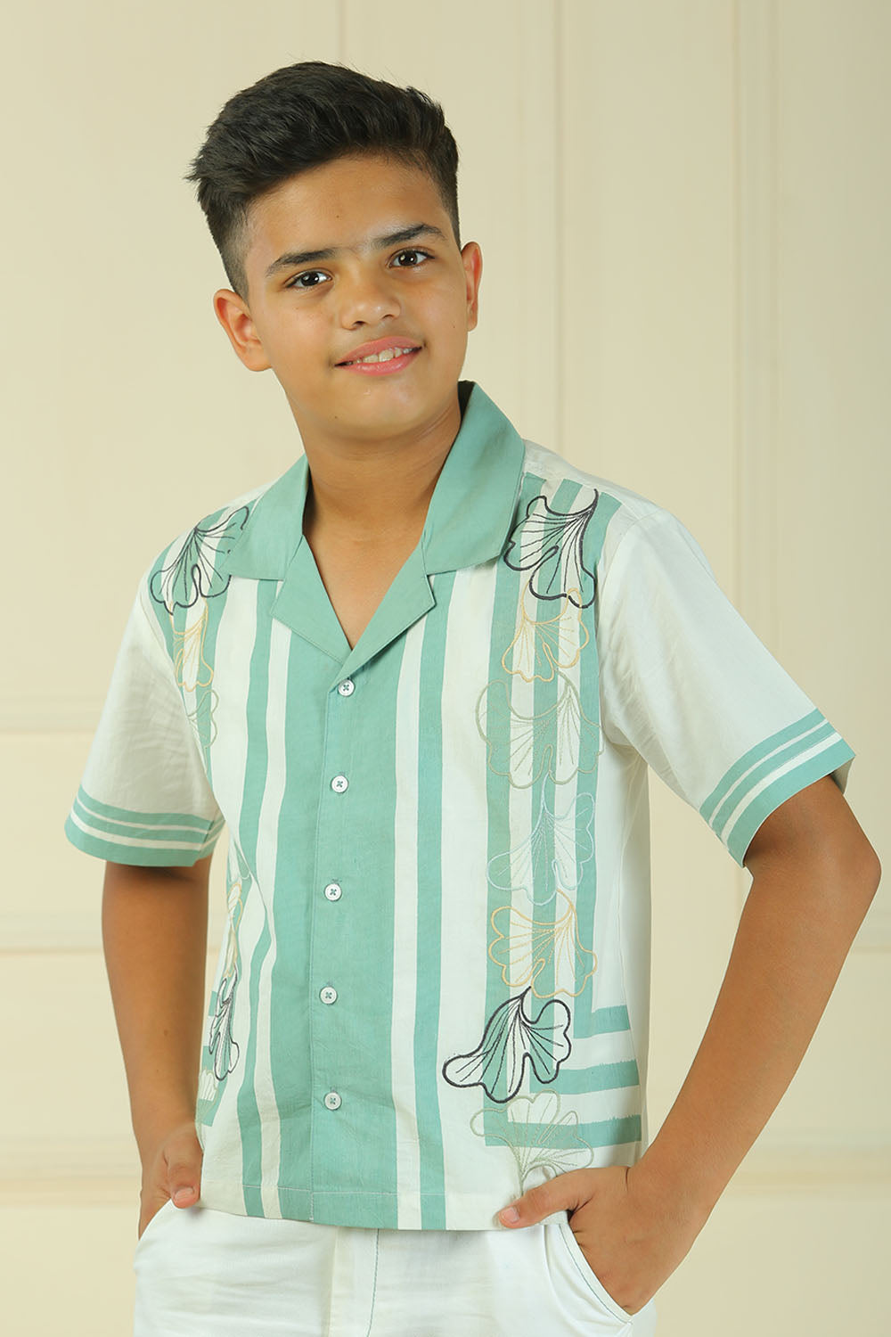 Luxe & Hardy Tundra Trek Shirt – close-up portrait of teal green white striped short sleeve boys shirt with embroidery detail, kids party wear casual shirt, indoor setting