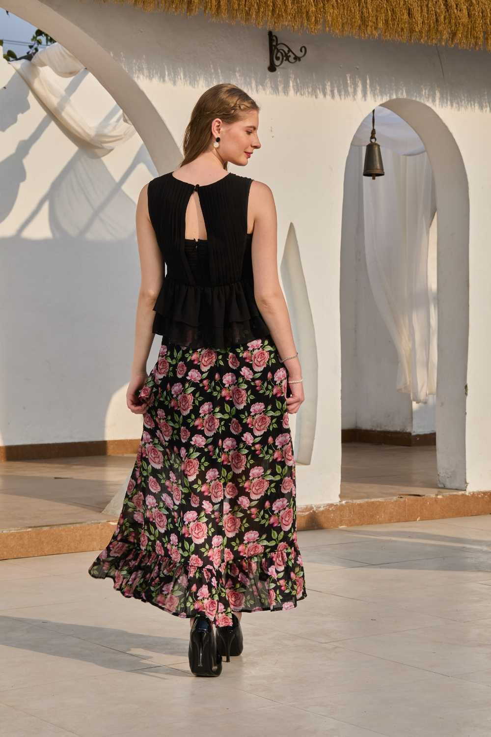 Luxe & Hardy Sera Rose Co-ord Set – three-quarter view walking pose, black pink floral slit dress style co ord set women, peplum top and asymmetric maxi skirt