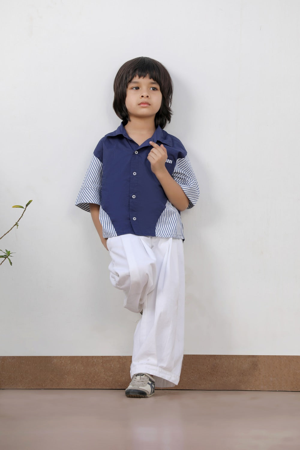 Luxe & Hardy Theo Blue Striped Shirt – full length front view of navy blue white stripe contrast panel short sleeve boys shirt with white wide leg pants, kids ethnic casual party wear shirt, indoor plant backdrop