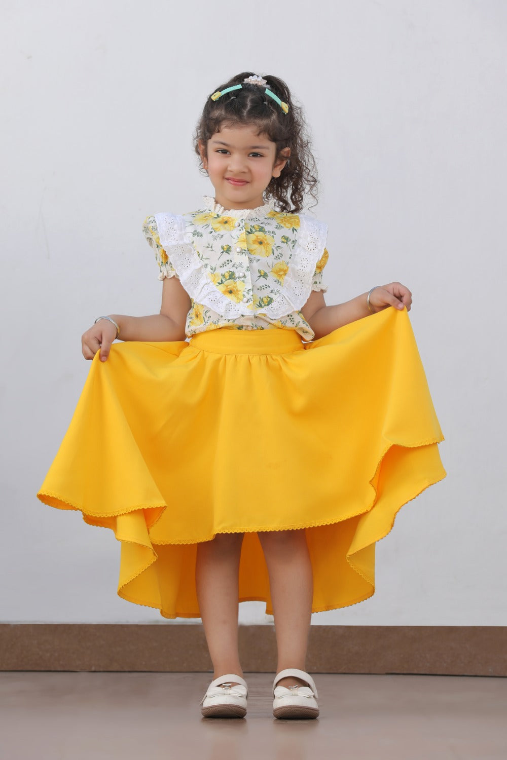 Girl holding out yellow high-low skirt, showing asymmetric hem detail