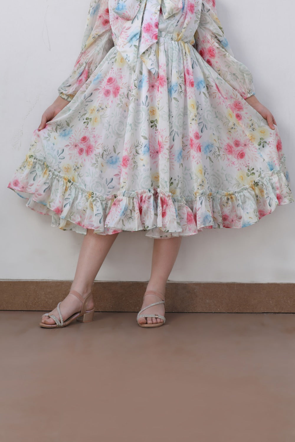 Full-length view of white floral midi dress showing tiered ruffle hem