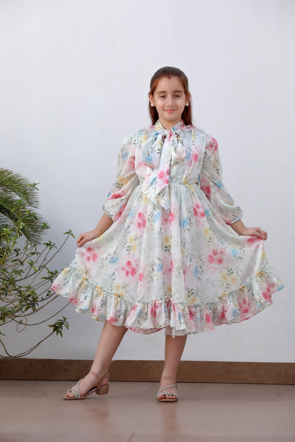 Full-length front view of white floral tiered midi dress with ruffle hem