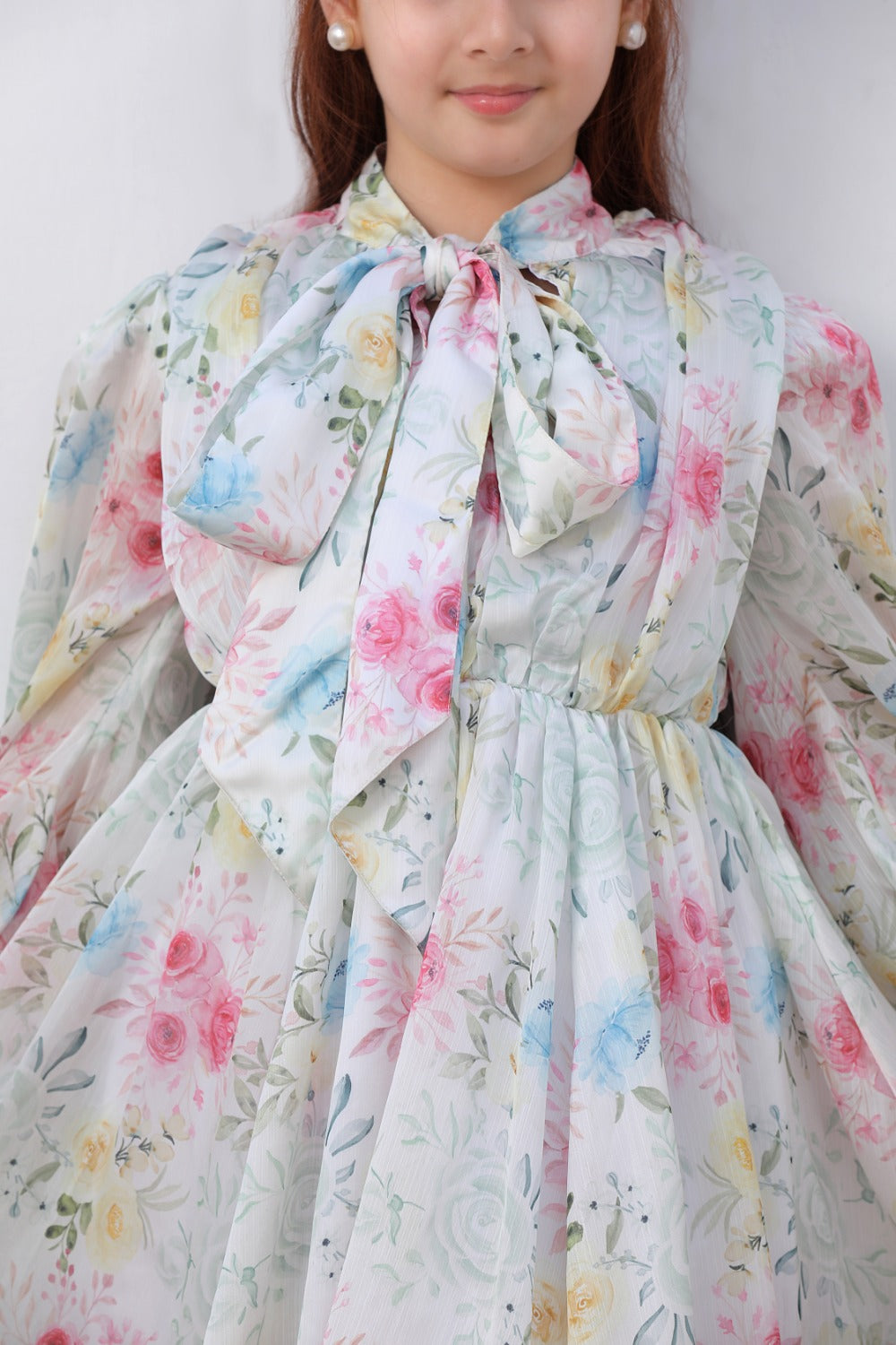 Close-up of bow tie neckline and pink floral print on dress bodice