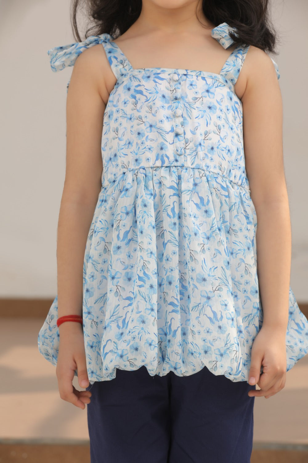 Close-up of blue floral balloon top with shoulder tie detail