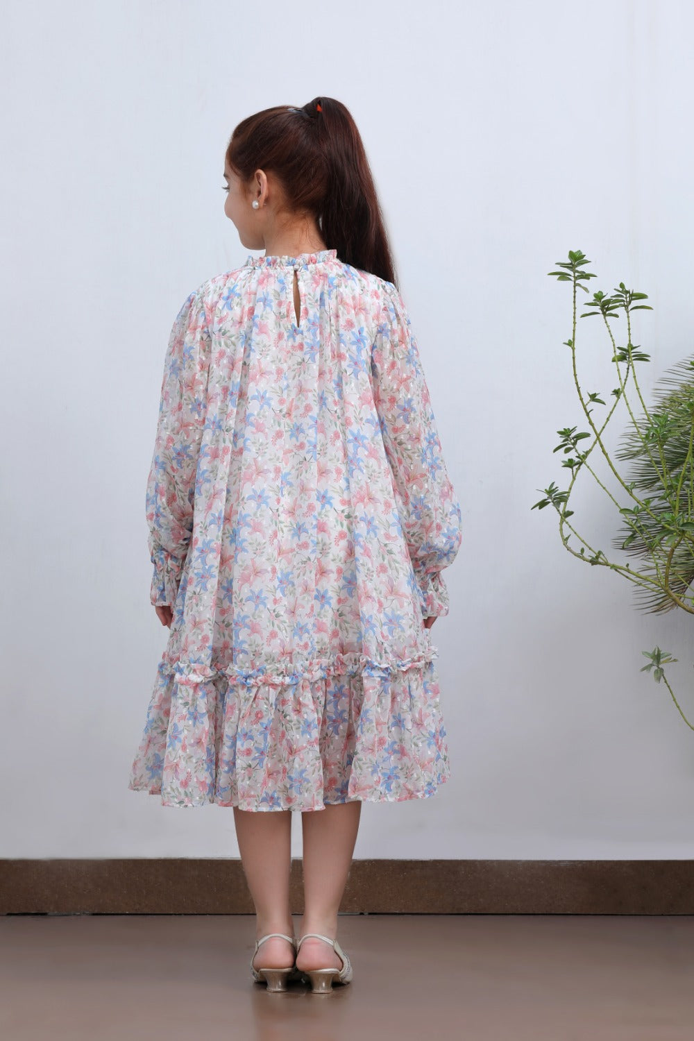 Back view of girl in white floral long-sleeve midi dress