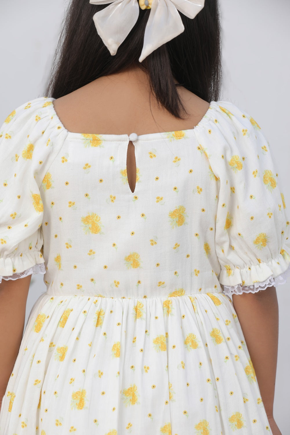 Back view of cream floral dress showing keyhole or button back detail