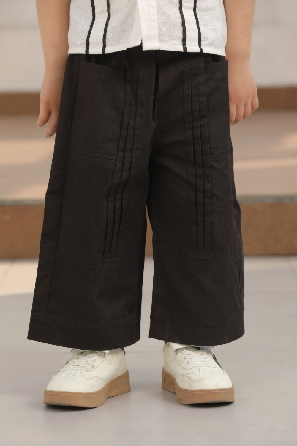 Luxe & Hardy Everwood Panel Pant – close-up front view of black wide leg panel palazzo pants for boys, kids ethnic party wear bottom wear, white sneakers styling