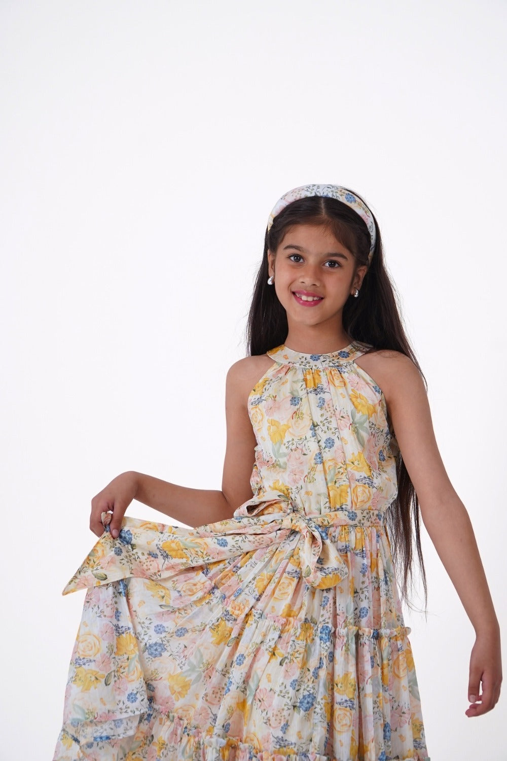 Girl in yellow floral halter dress with matching accessories, styled outfit shot