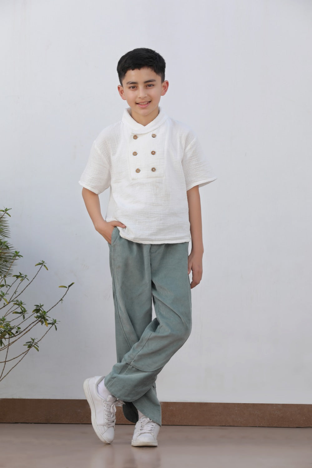 Luxe & Hardy Milo Textured Tee – full length standing pose of white textured linen short sleeve double button boys shirt with sage green relaxed pants, kids ethnic festive casual shirt