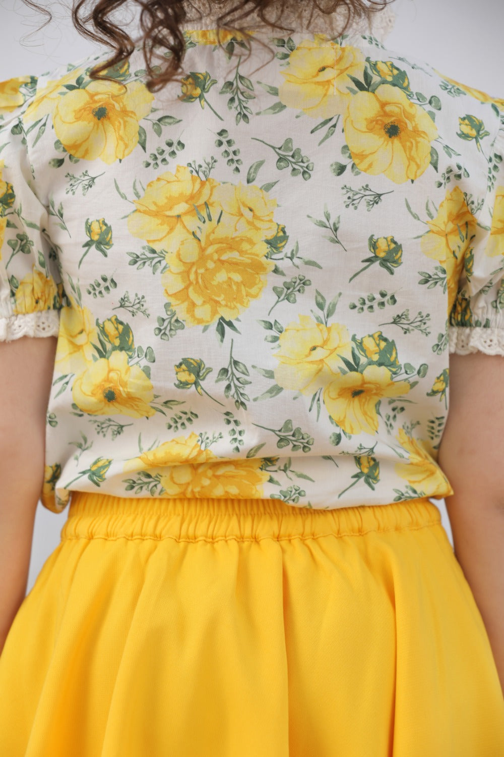 Close-up of yellow and white floral print on puff-sleeve top bodice