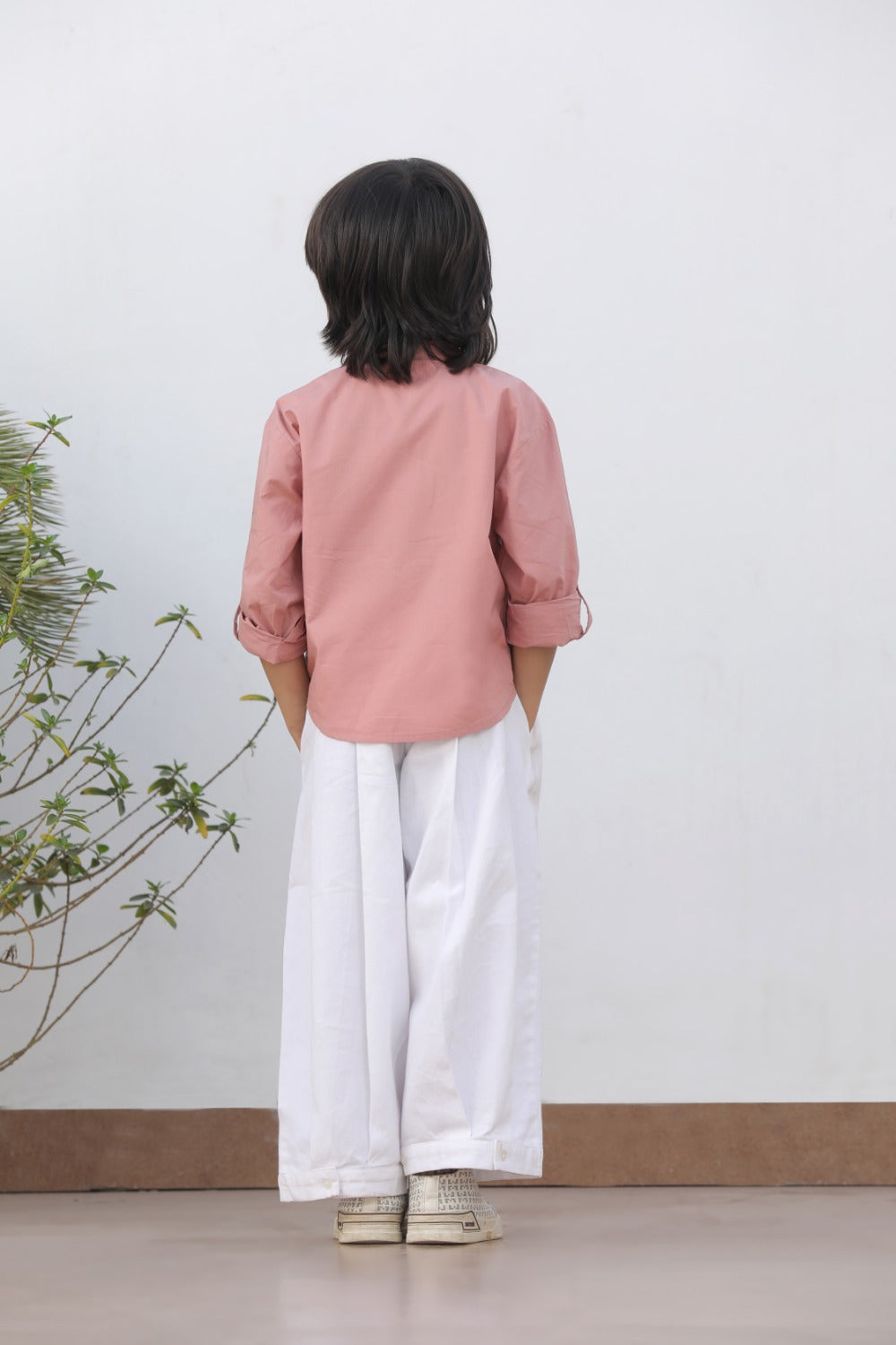 Luxe & Hardy Henry Relaxed Pants – three-quarter view of white wide leg relaxed linen boys pants, toddler kids ethnic casual bottom wear, styled with pink long sleeve shirt indoors
