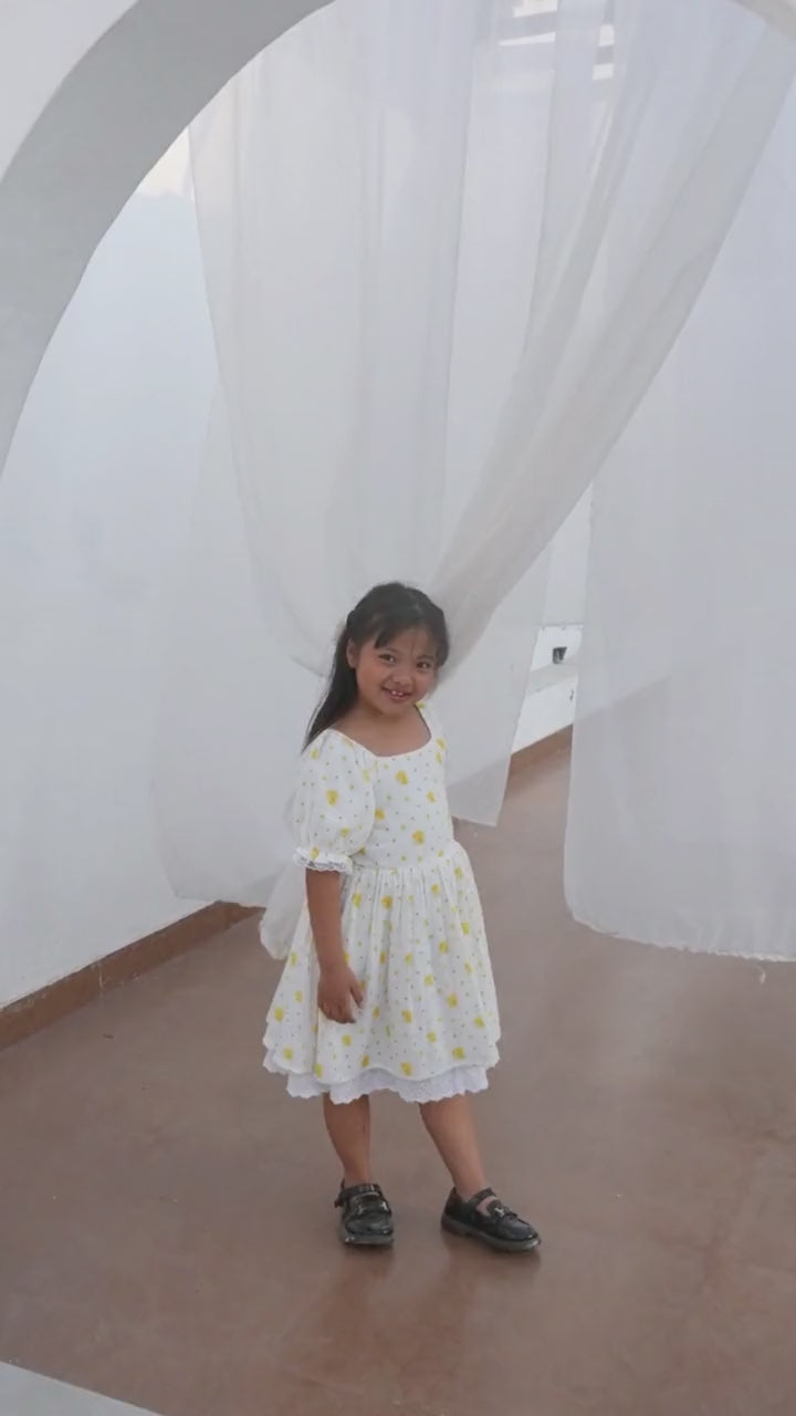 Girl in cream and yellow floral lace dress in bright indoor setting — video preview
