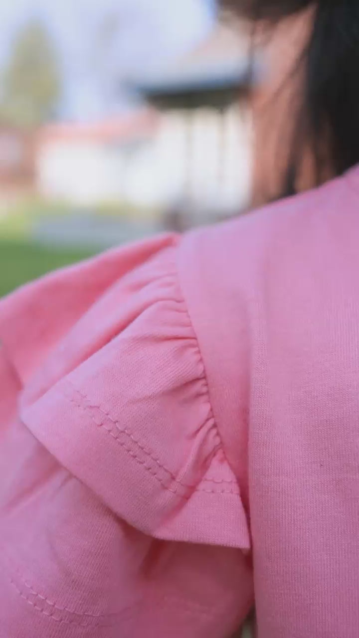 Close-up of coral ruffle sleeve detail on girls tee — video preview