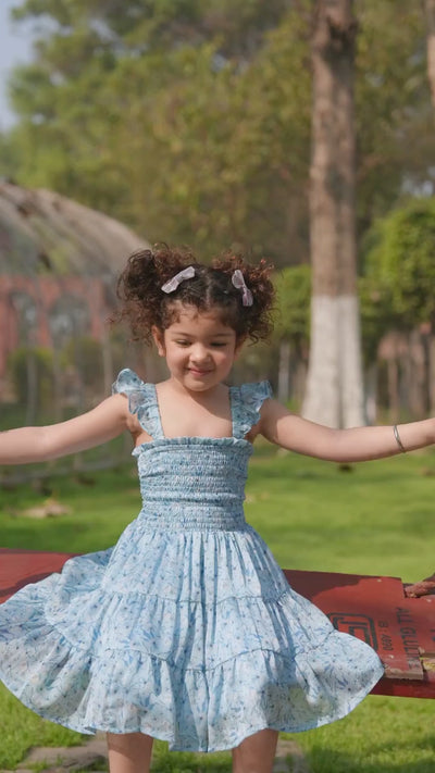 Girl in blue floral tiered dress posing outdoors in natural light — video preview